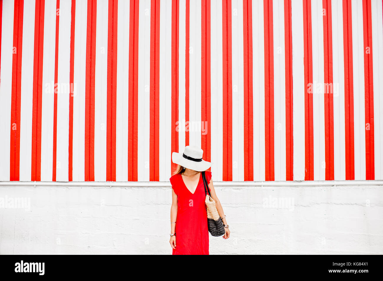Woman on the red striped wall background Stock Photo Alamy