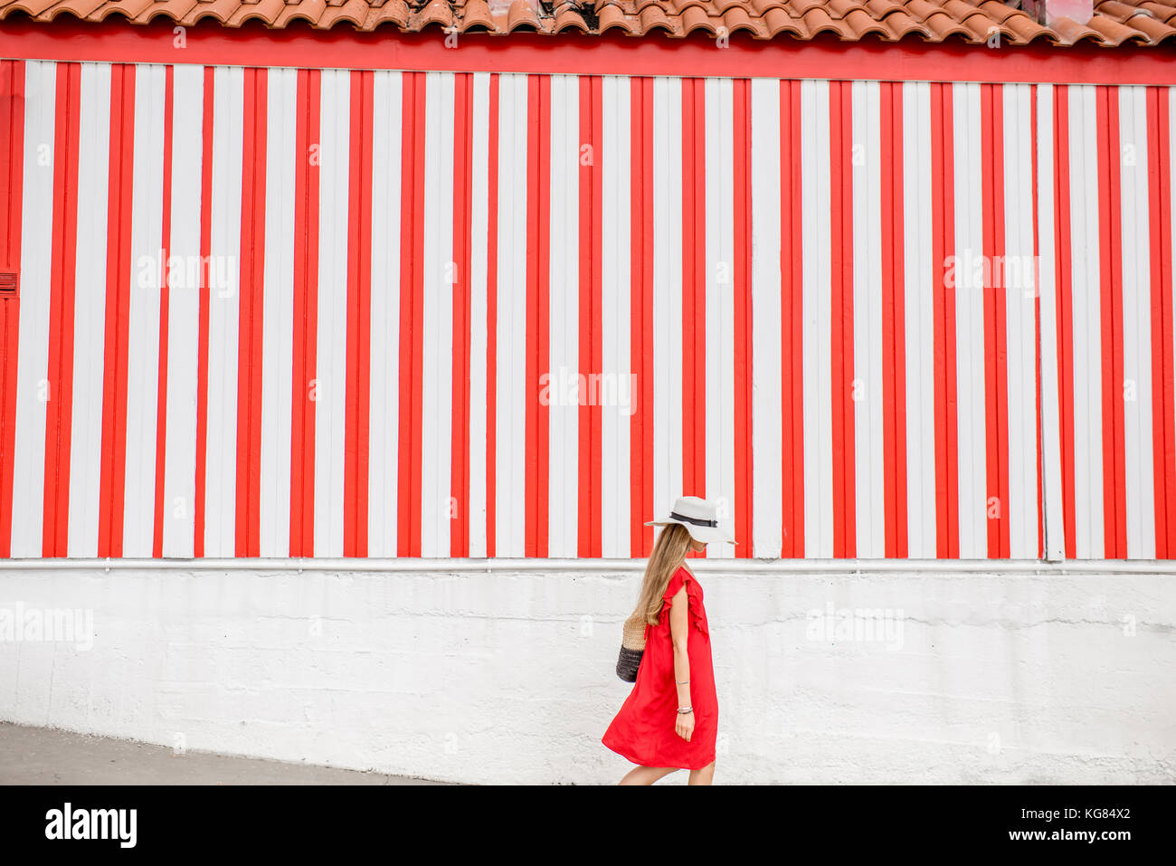 Woman on the red striped wall background Stock Photo Alamy
