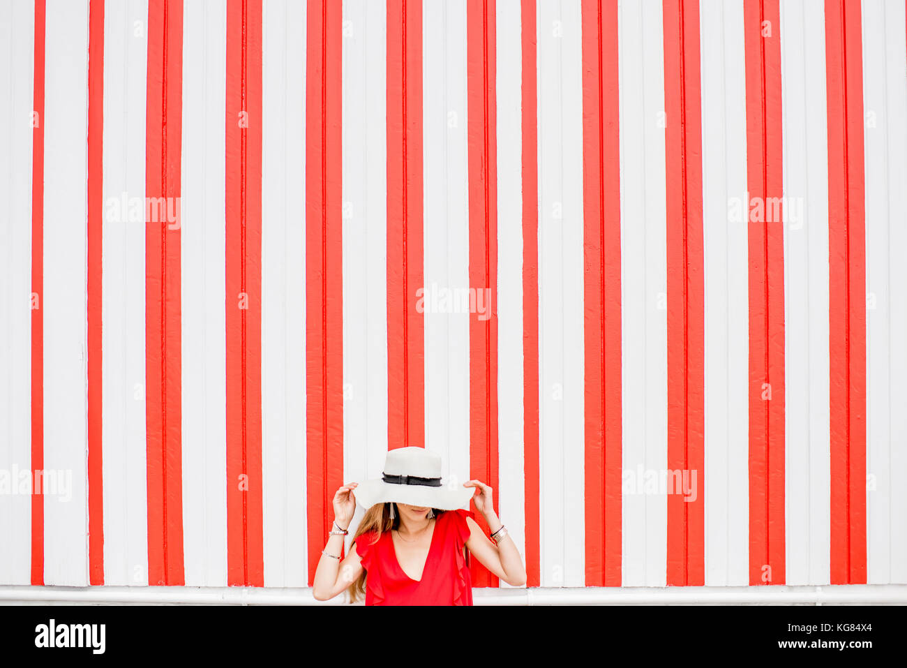 Woman on the red striped wall background Stock Photo Alamy