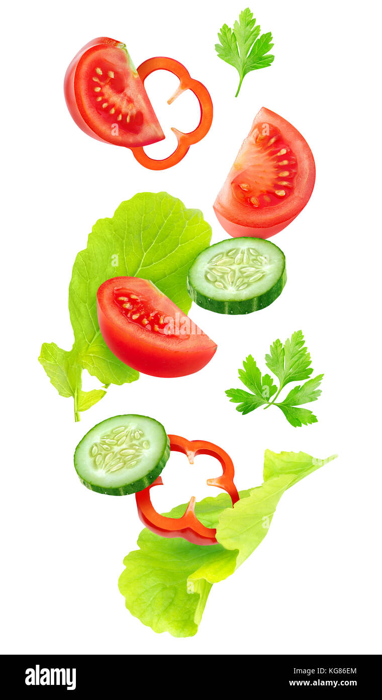 Isolated falling vegetables. Slices of tomato, cucumber, red bell pepper and lettuce leaves (fresh salad ingredients) in the air isolated on white bac Stock Photo