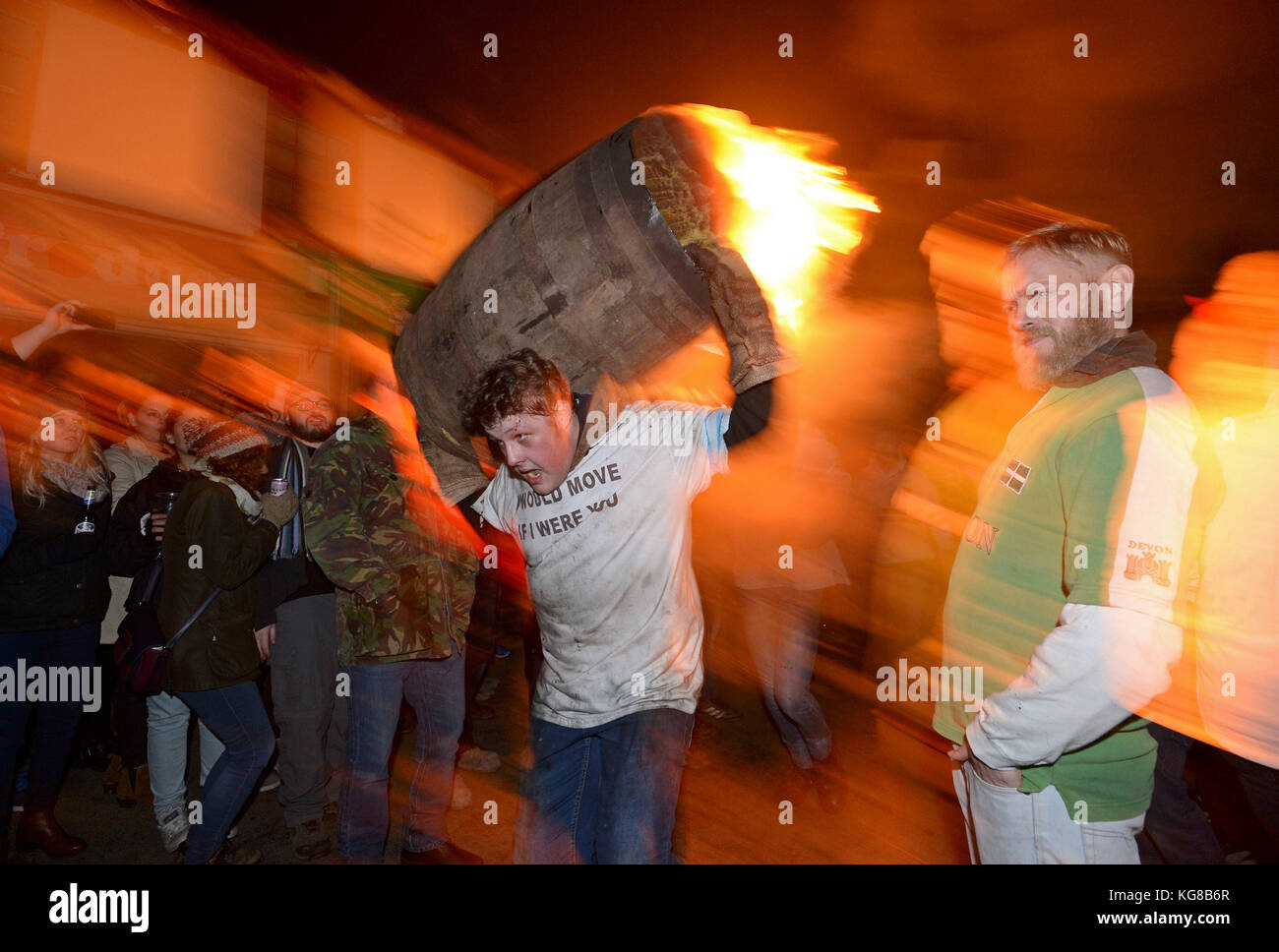 Participants run with a burning barrel soaked in tar at the annual Ottery St Mary tar barrel festival in Devon, UK Credit: Finnbarr Webster/Alamy Live News Stock Photo