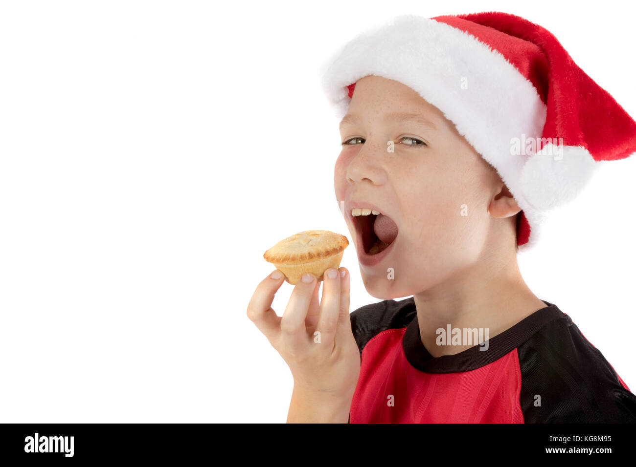 Pre-teen boy in christmas hat and a mince pie Stock Photo
