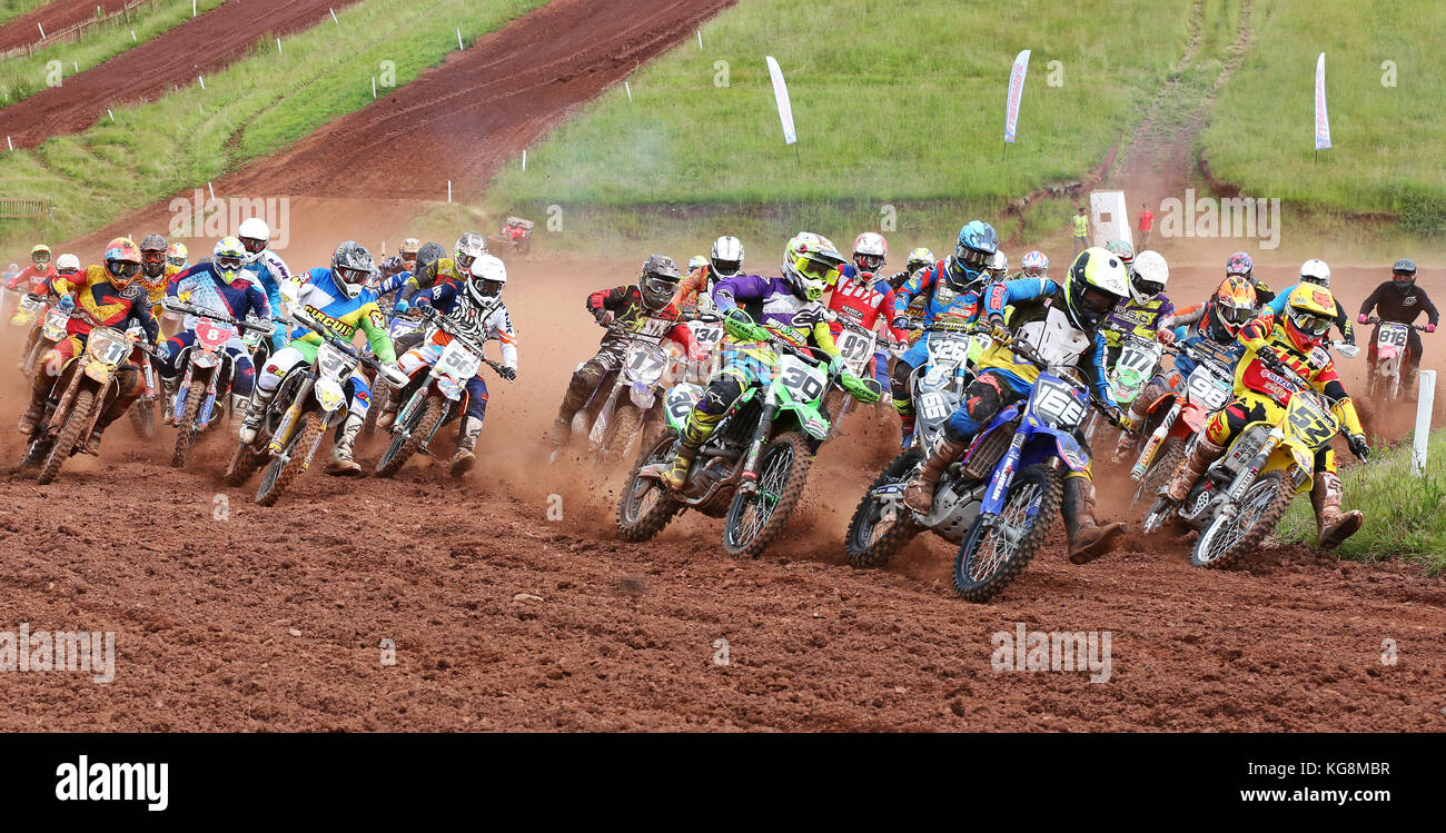 Motocross bikes approach the first corner in race Stock Photo Alamy
