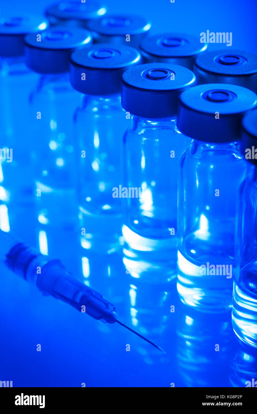 Vials of the vaccine, blue background Stock Photo - Alamy