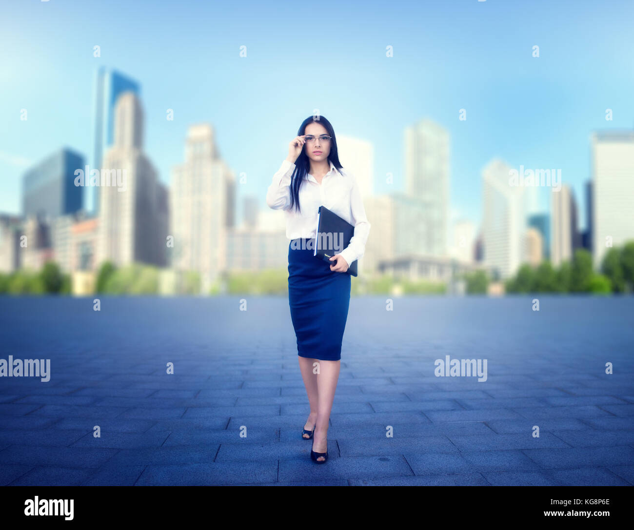Portrait of young business woman in glasses and white blouse with ...