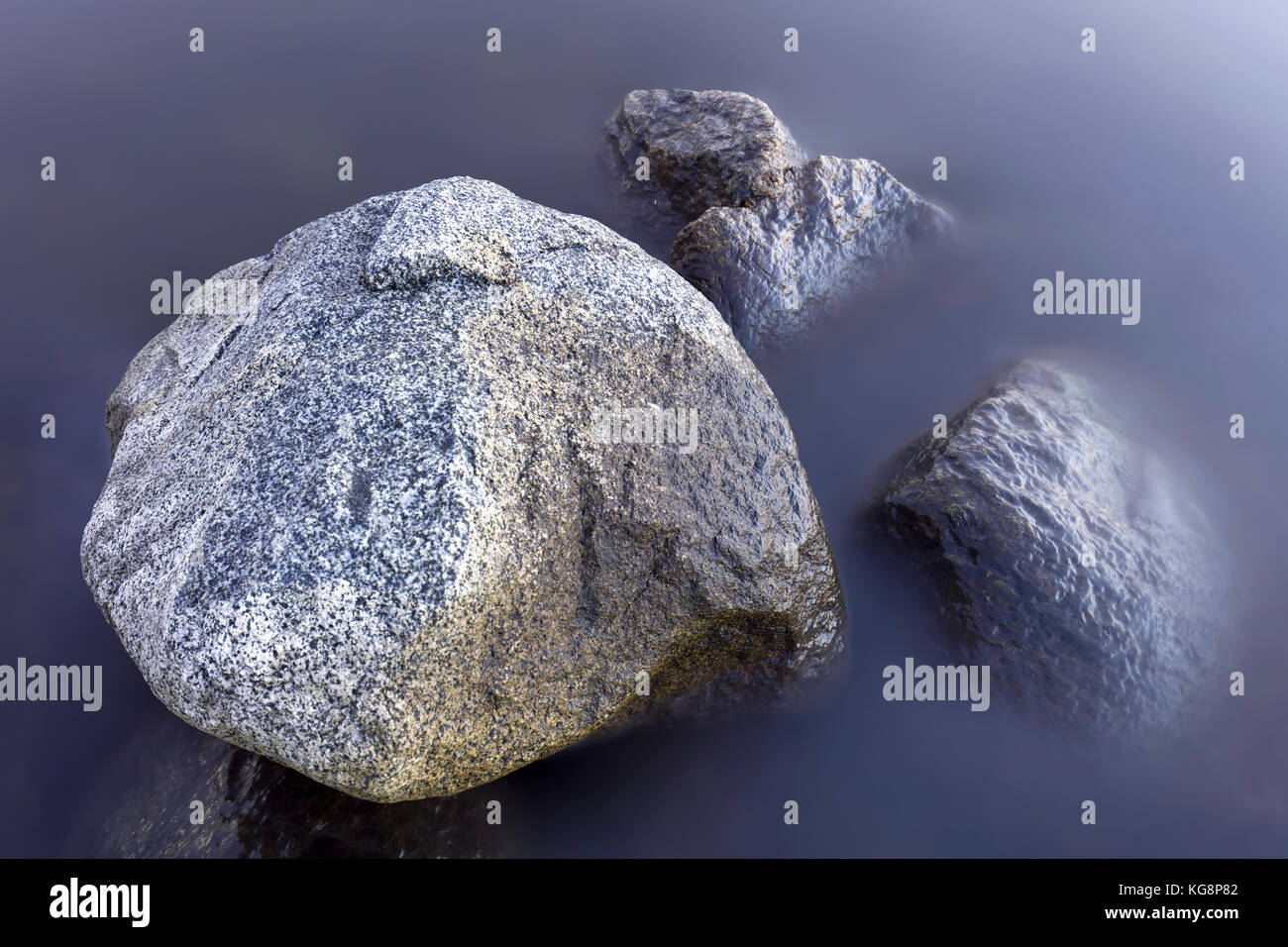 Stones sticking out of the twilight sea Stock Photo