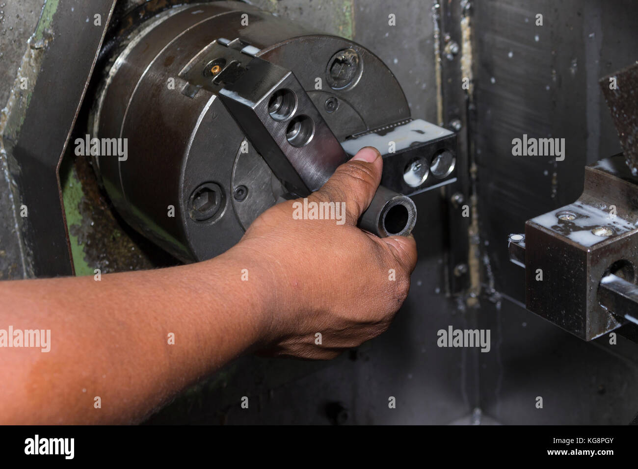 man load workpiece into lathe machine clamping Stock Photo 164921147