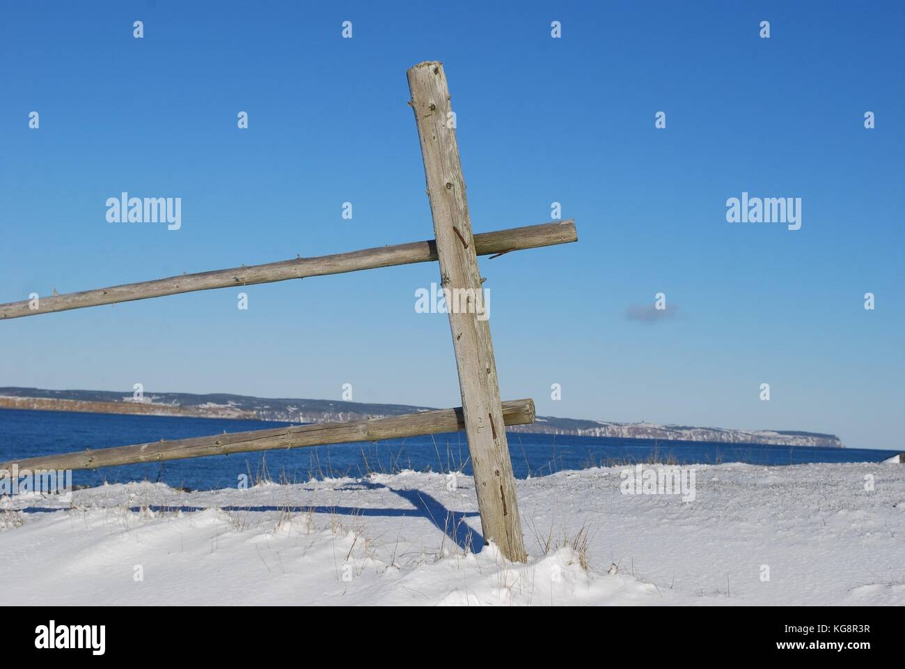 Fence post and two rails of an old, disused fence along the shoreline, Conception Bay South, Newfoundland Stock Photo