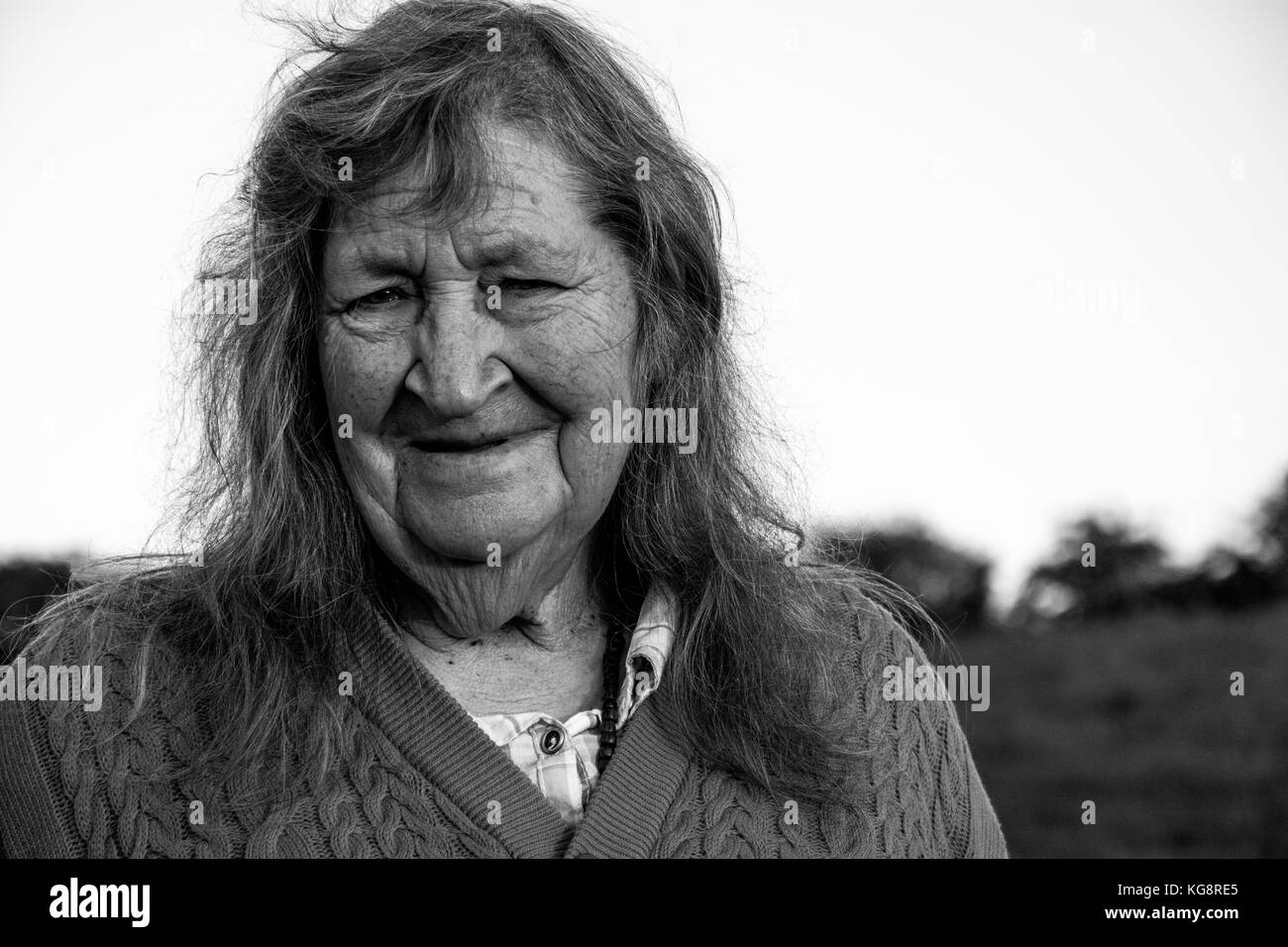 A candid portrait of an elderly (old) woman without her dentures in. Taken outside in the country. Much Wenlock, Shropshire, UK Stock Photo