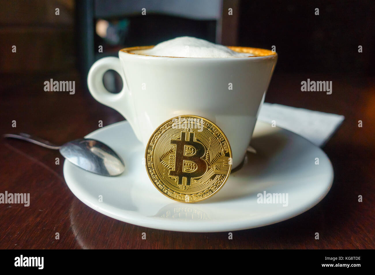 Capuccino and bitcoin gold coin on the table in cafe Stock Photo - Alamy