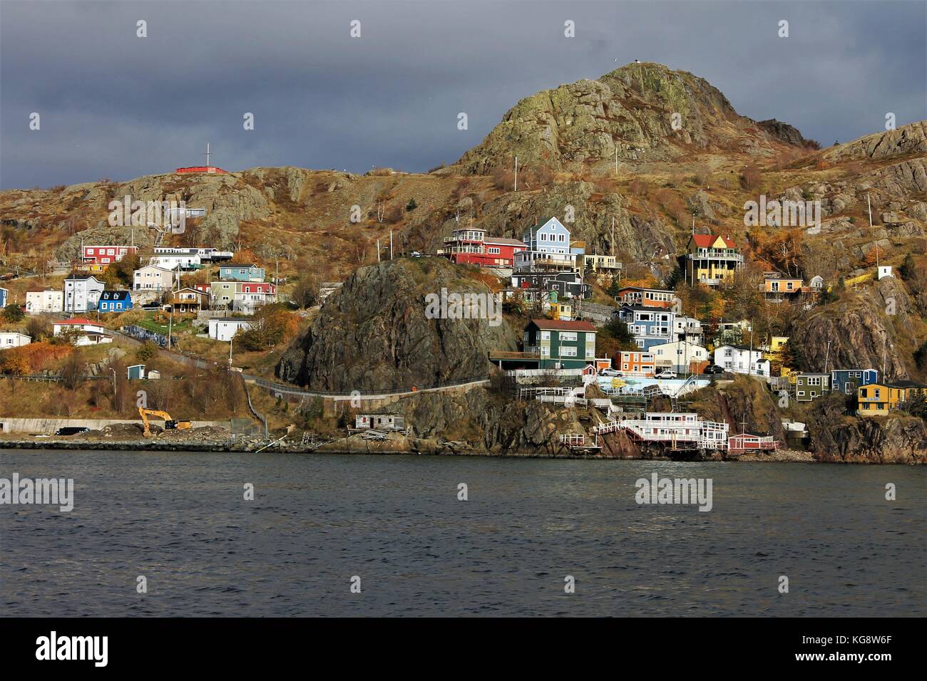 Storm Clouds gather over Signal Hill while the sun still shines on the Battery, Signal Hill, St. John's, Newfoundland. Stock Photo