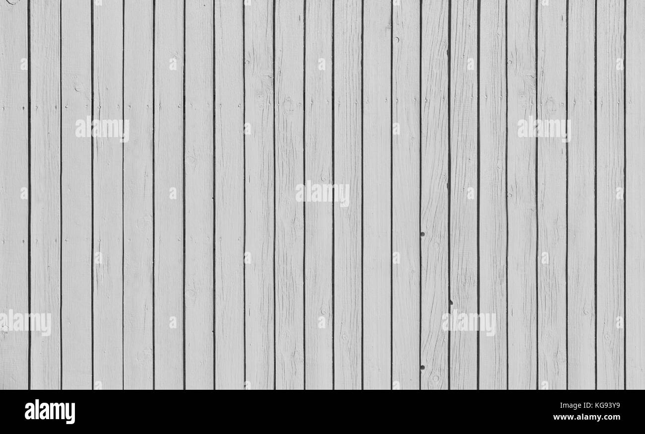 Wooden slat fence with parallel planks with white paint. Stock Photo
