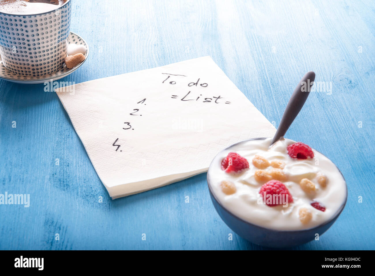 Cup of Arabic coffee, a bowl of yogurt with raspberry and cereal and a