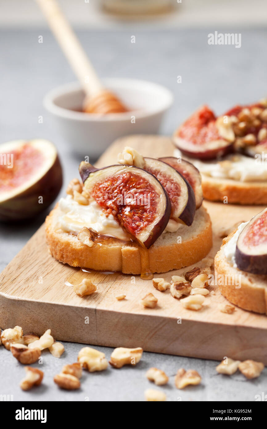 sandwiches with figs, ricotta, honey and walnuts on a gray background