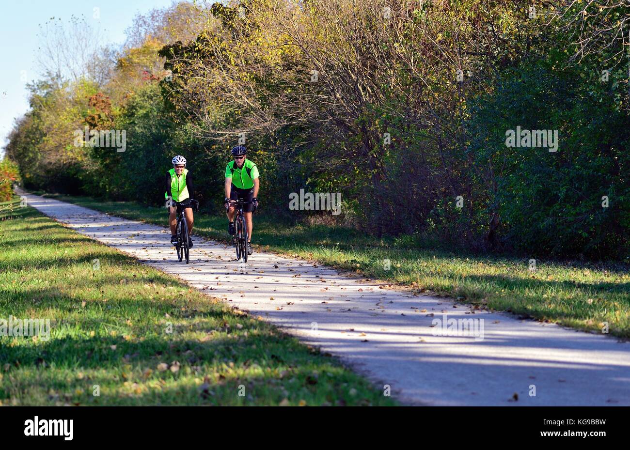 Pair of cyclists making their way along a section of the Illinois Prairie Path. West Chicago, Illinois, USA. Stock Photo