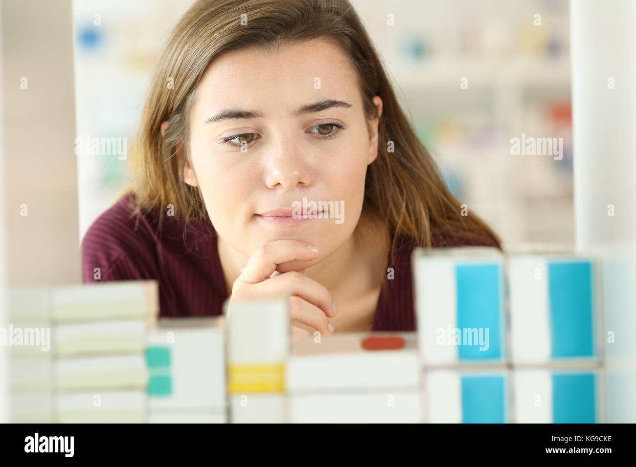 Front view of a doubtful customer choosing medicines in a pharmacy Stock Photo