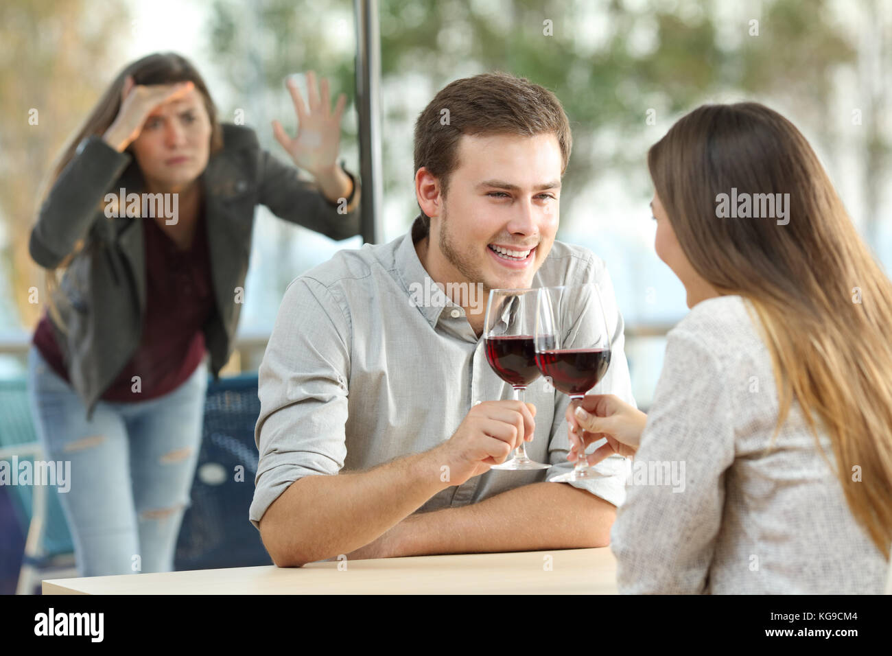 Obsessed ex girlfriend spying to a couple dating in a coffee shop Stock Photo