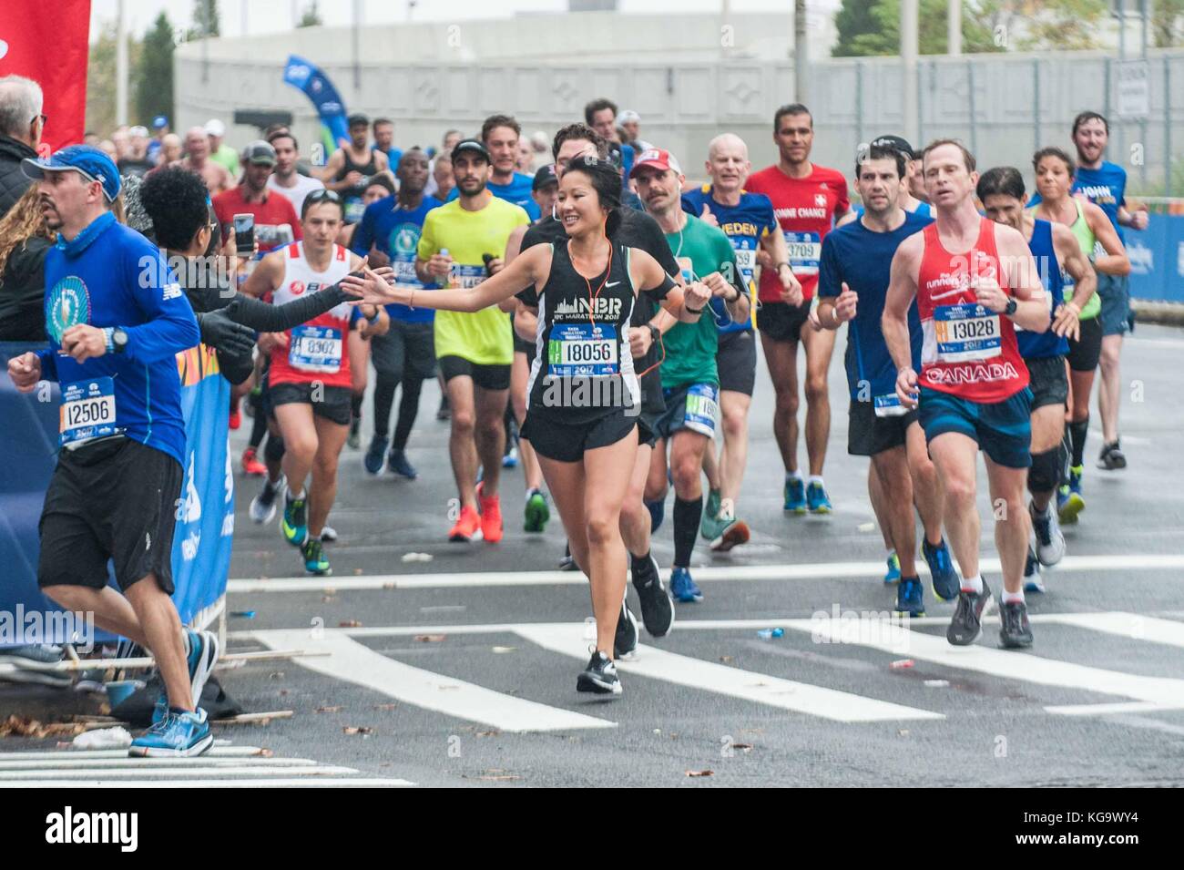 New York, USA. 5th Nov, 2017. A female runner high fives onlooker. Runners in the New York City marathon on November 5, 2017 near the 20 mile marker in Bronx, NY Credit: Brigette Supernova/Alamy Live News Stock Photo