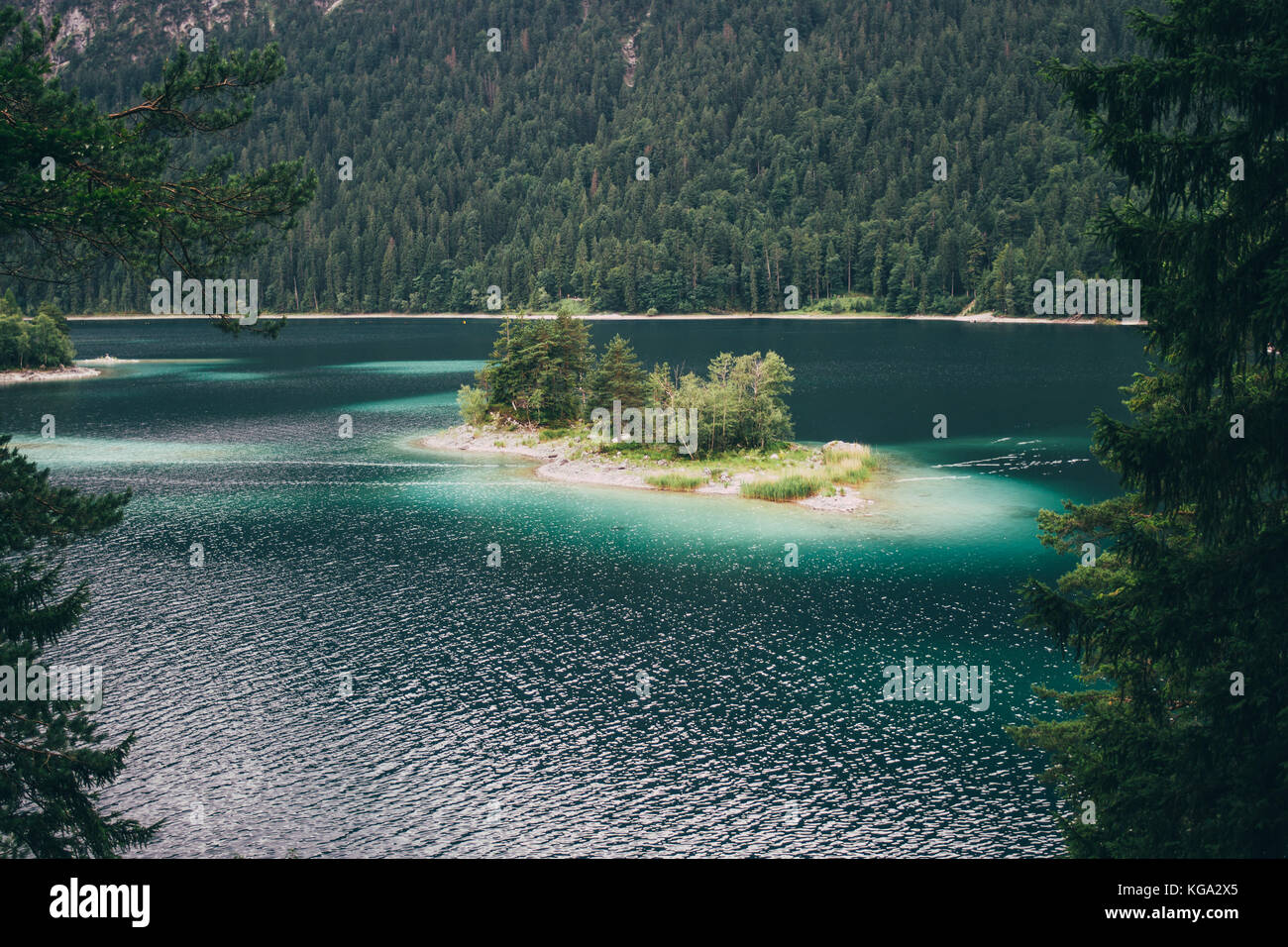 Island with clear blue water on the EIbsee mountain lake in the Alps in Germany. Stock Photo