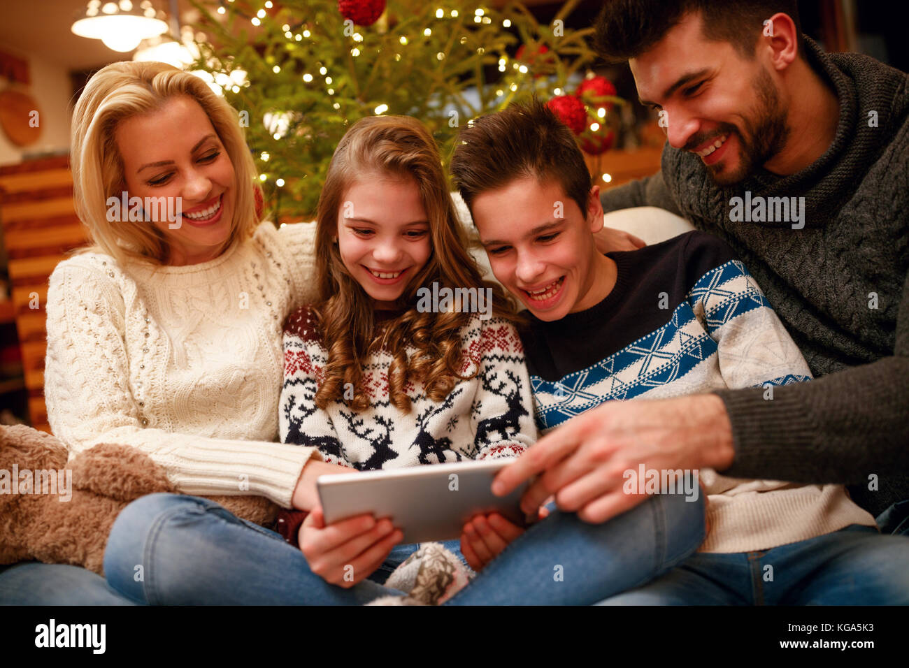 smiling family having fun on digital tablet for Christmas time Stock Photo