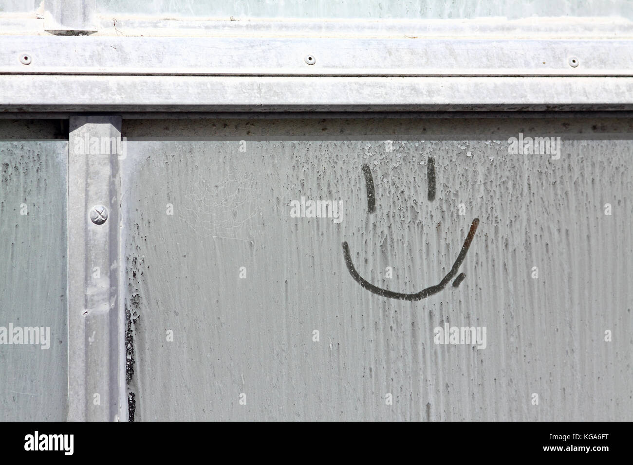 Smiley face drawn on a window Stock Photo
