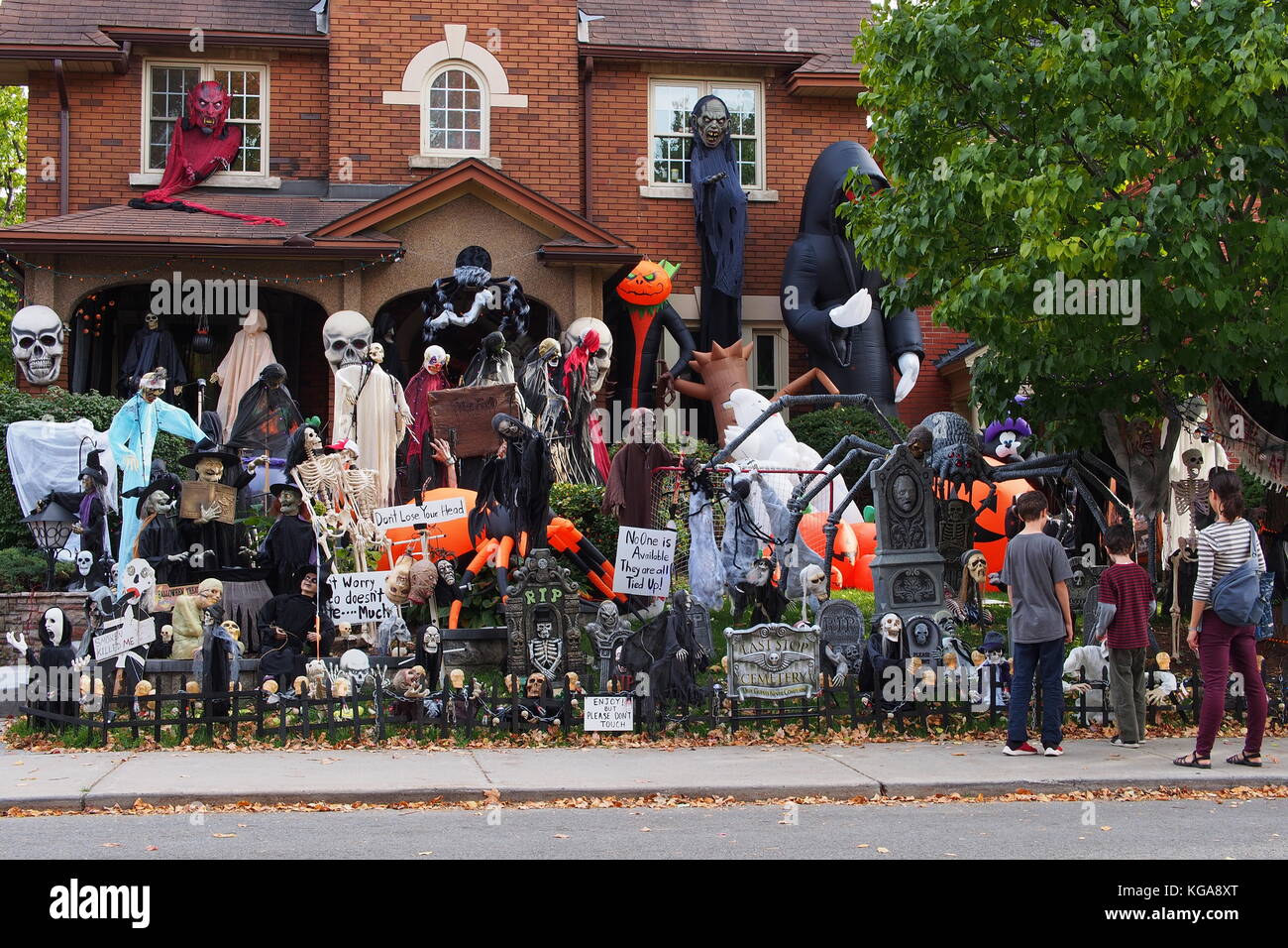 A family stops to view the elaborate Halloween garden decorations