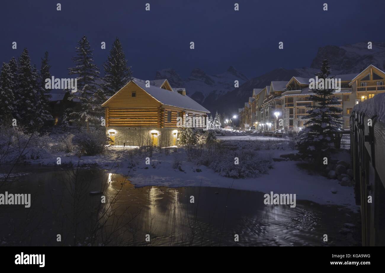 Log Cabin Night Lights in Spring Creek Mountain Village Residential Condo Building Complex near Canmore City Center at Christmas in Alberta Foothills Stock Photo