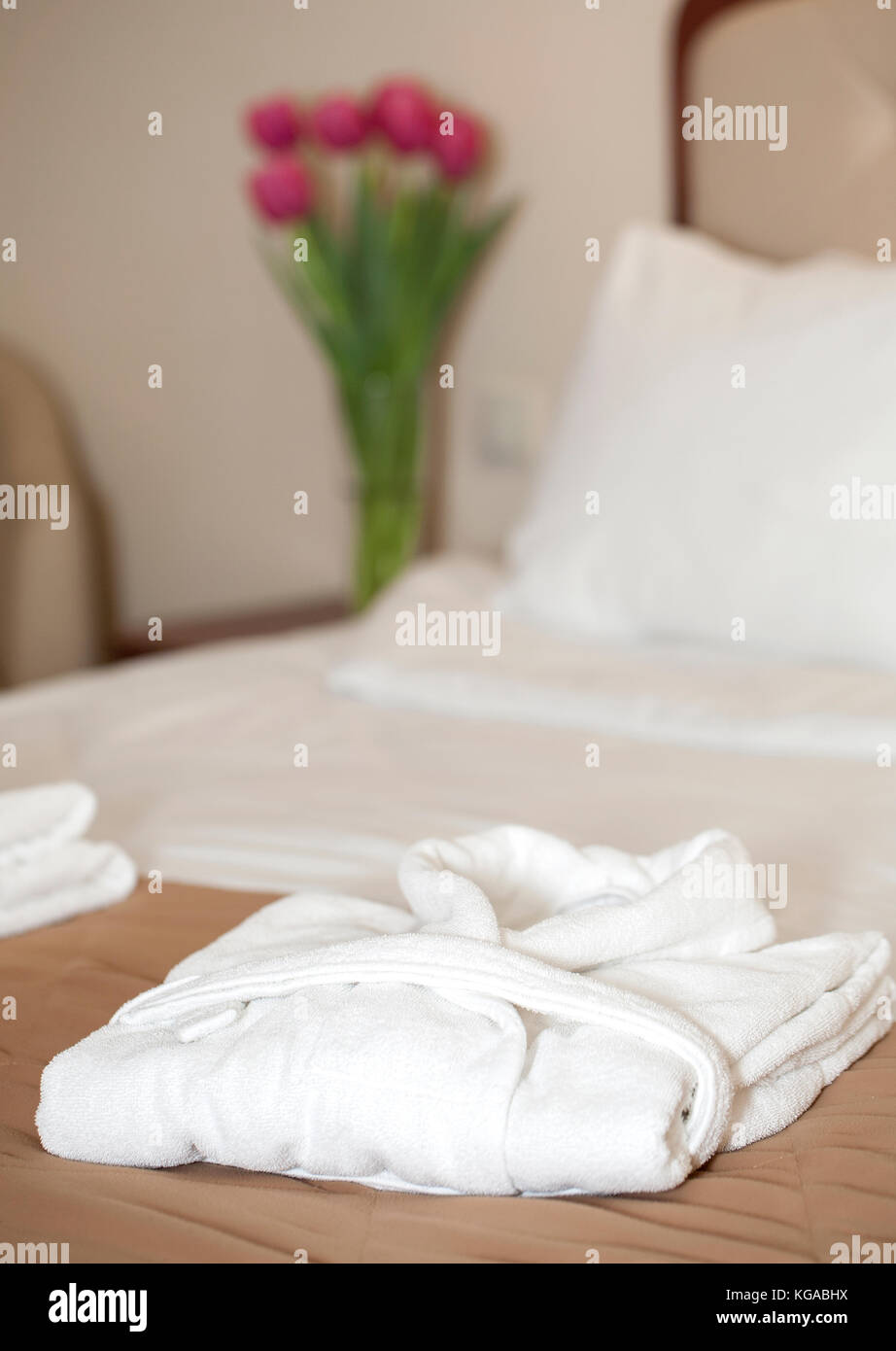 hotel room with white bathrobe on the bed Stock Photo Alamy