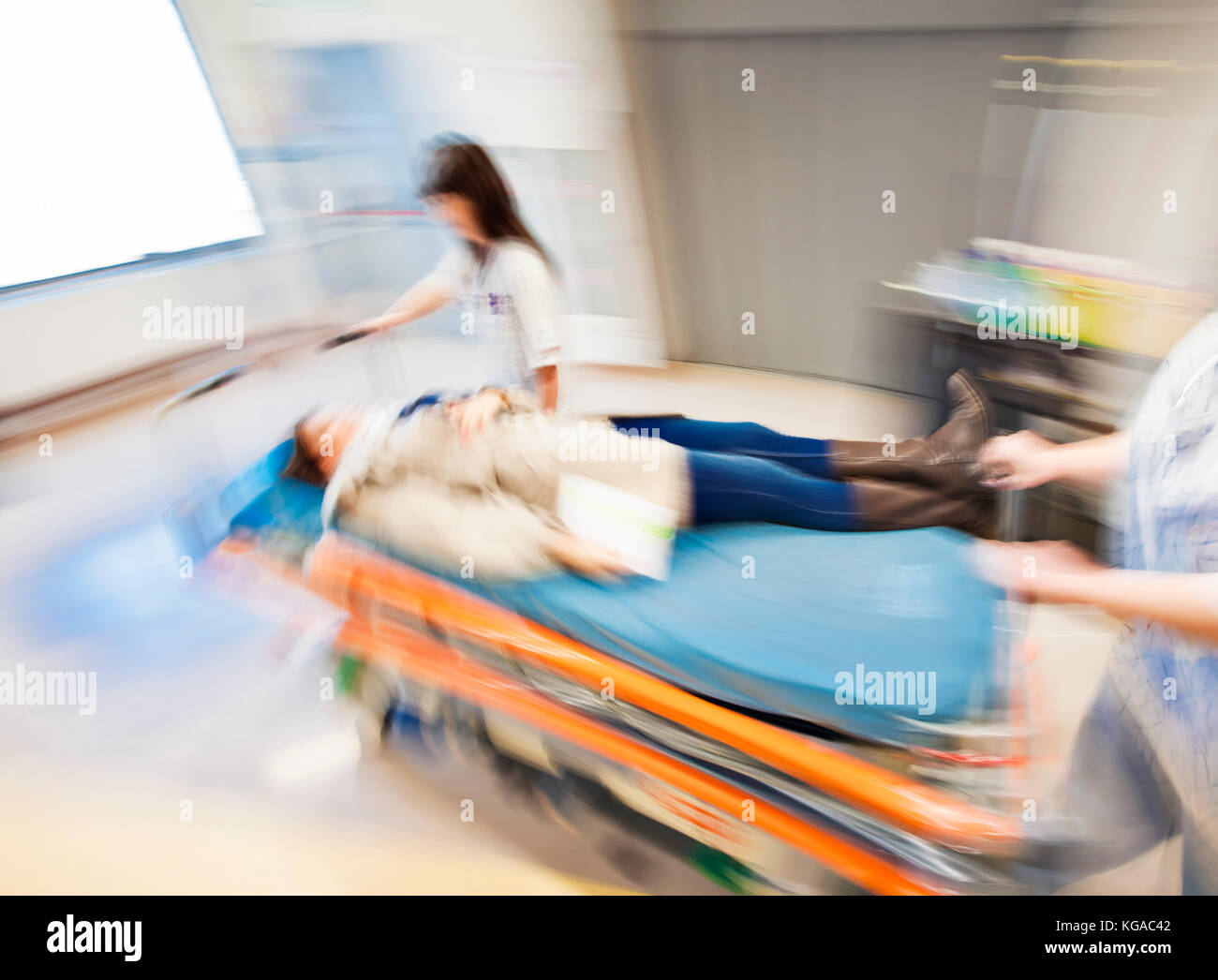 An emergency litter with patient, pushed fast through modern hospital