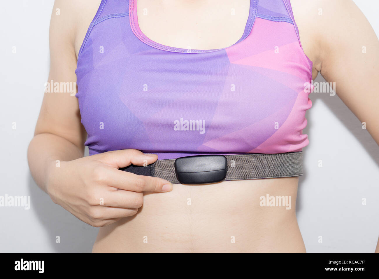 Young Woman in sport bra and heart rate monitor with tape isolated on