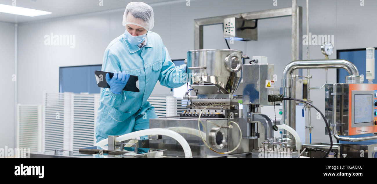 A Machine Making Science scientist making notes about machine Stock Photo - Alamy