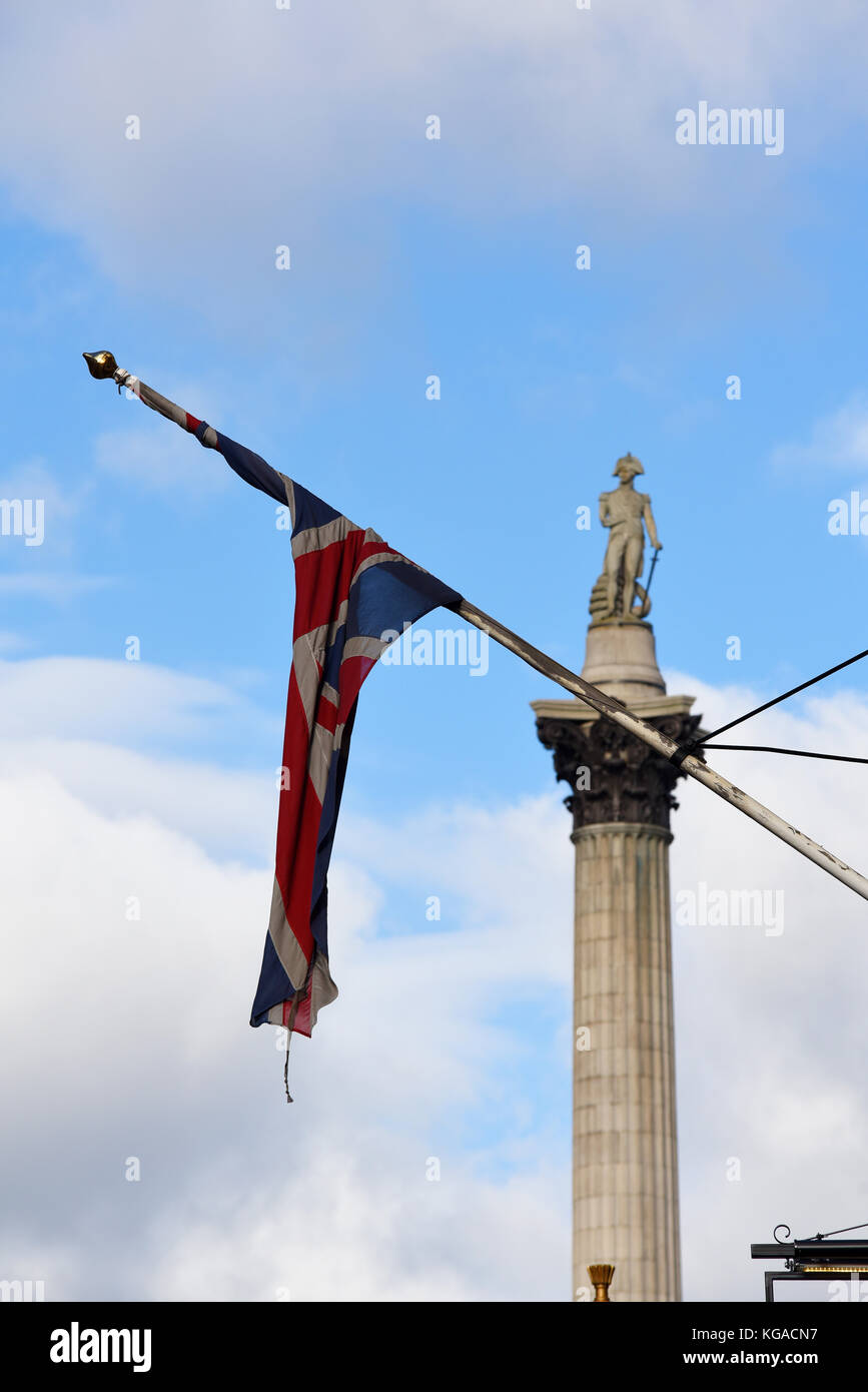 Union jack flag caught up around the flag pole with Nelson's Column, Trafalgar Square, Whitehall, London. Space for copy Stock Photo