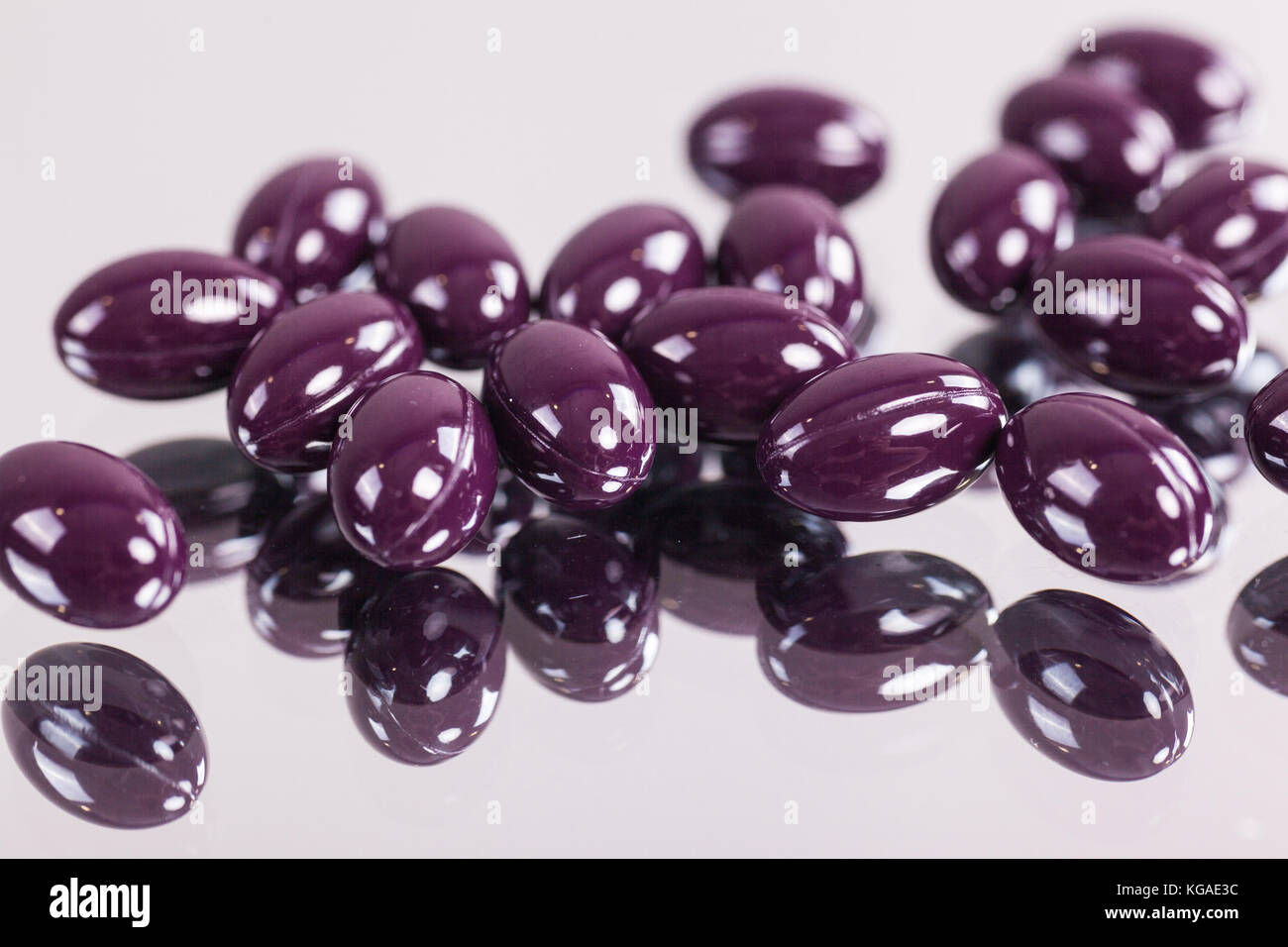capsules purple pills closeup on mirror surface Stock Photo Alamy