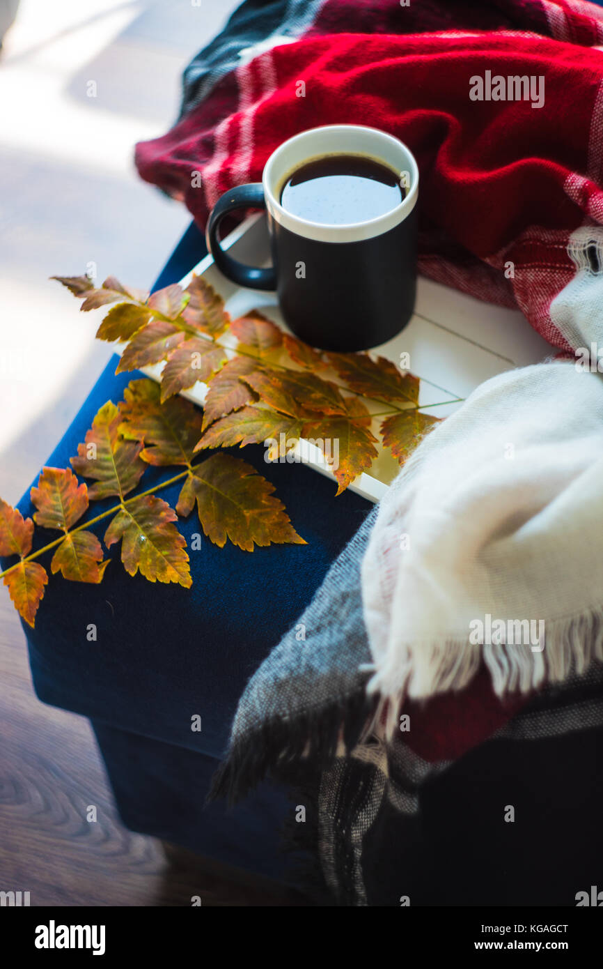 Autumnal concept with bright yellow leaves and cup of coffee in rustic ...