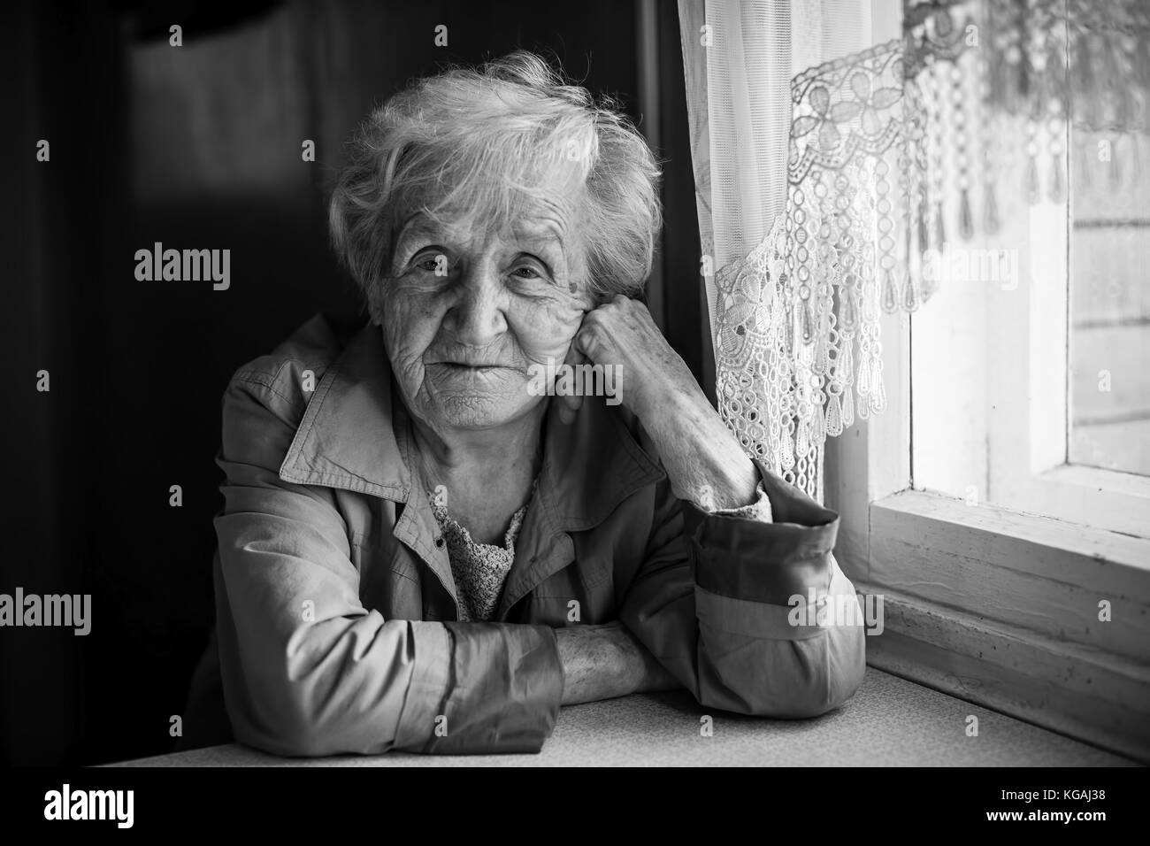 Black and white portrait of an elderly woman sitting in the house Stock ...