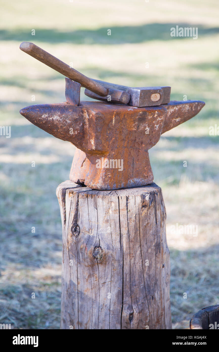 Two hammers with anvil on a wooden stump Stock Photo Alamy