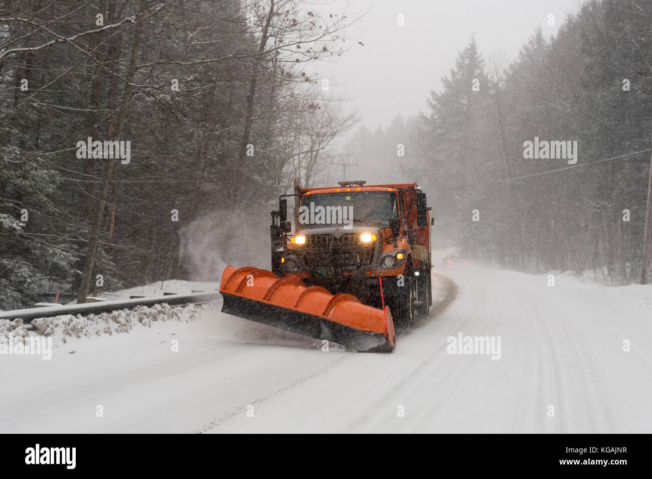 A snow plow clears the road as it snows in Vermont Stock Photo Alamy