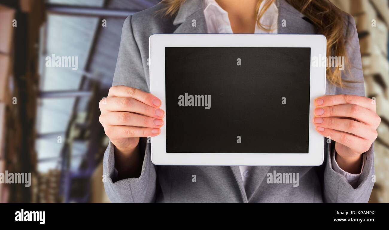 Digital composite of Woman holding tablet with office background Stock ...