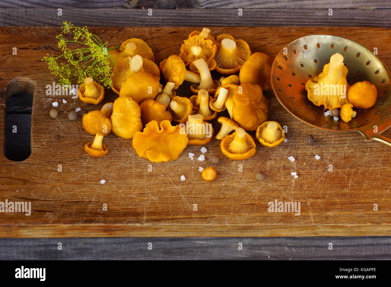 Chanterelles on the old oak kitchen board.п Stock Photo