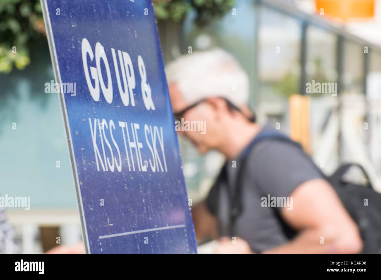 Billboard Go up and Kiss the sky, holidaymaker in background Stock Photo