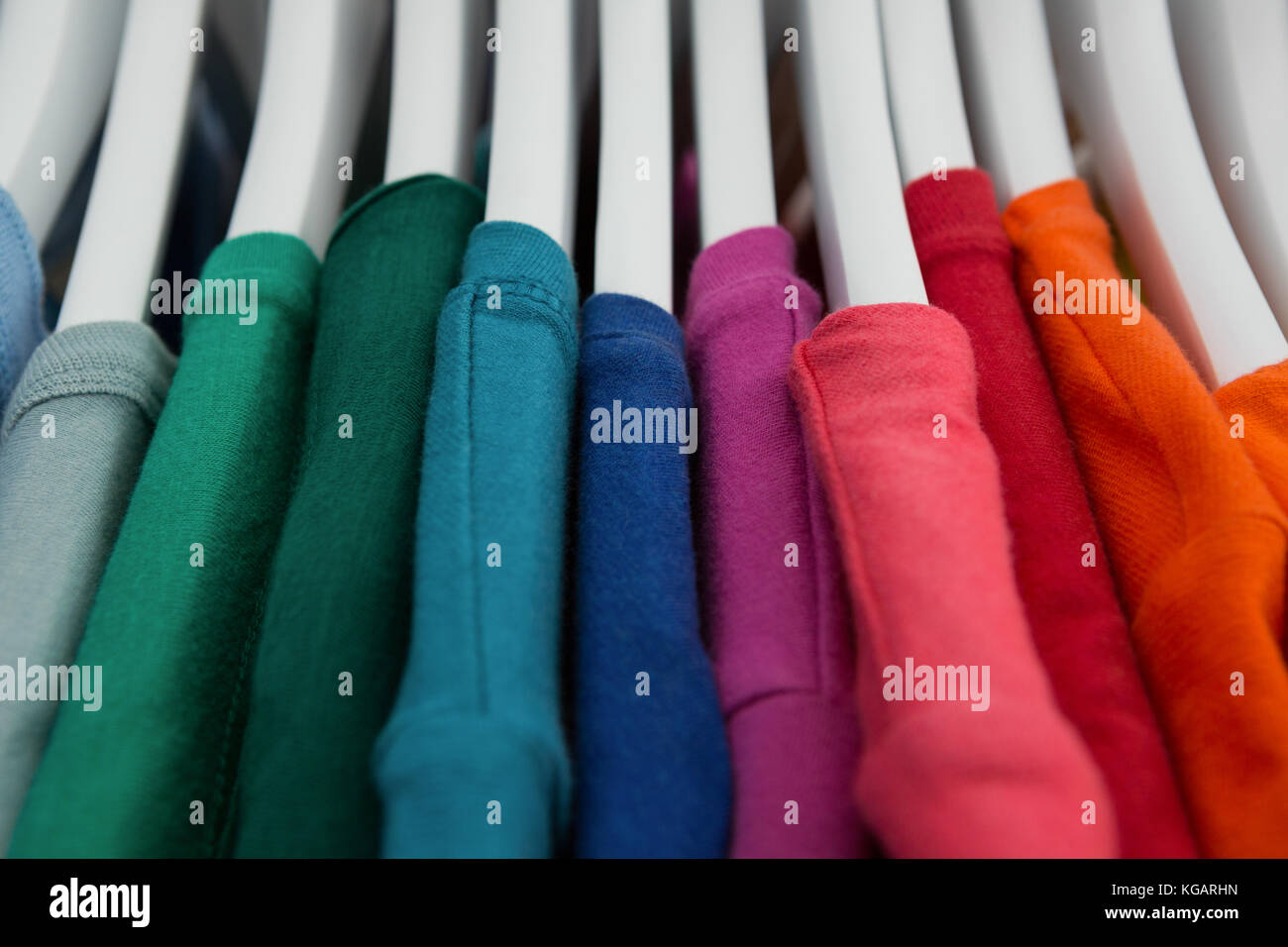 Close-up of various t-shirts hanging on cloth hanger Stock Photo