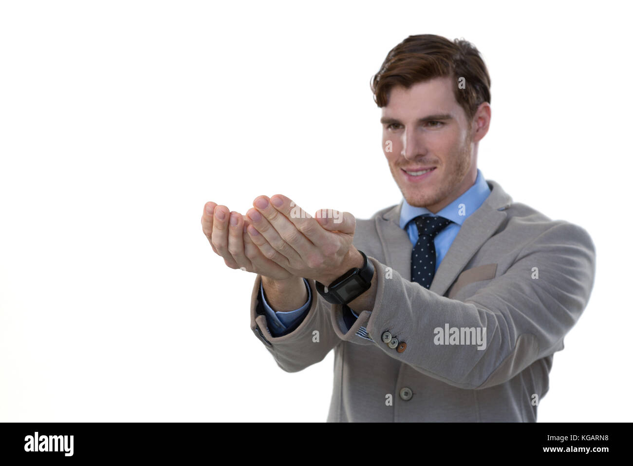 Businessman pretending to hold an invisible object against white background Stock Photo