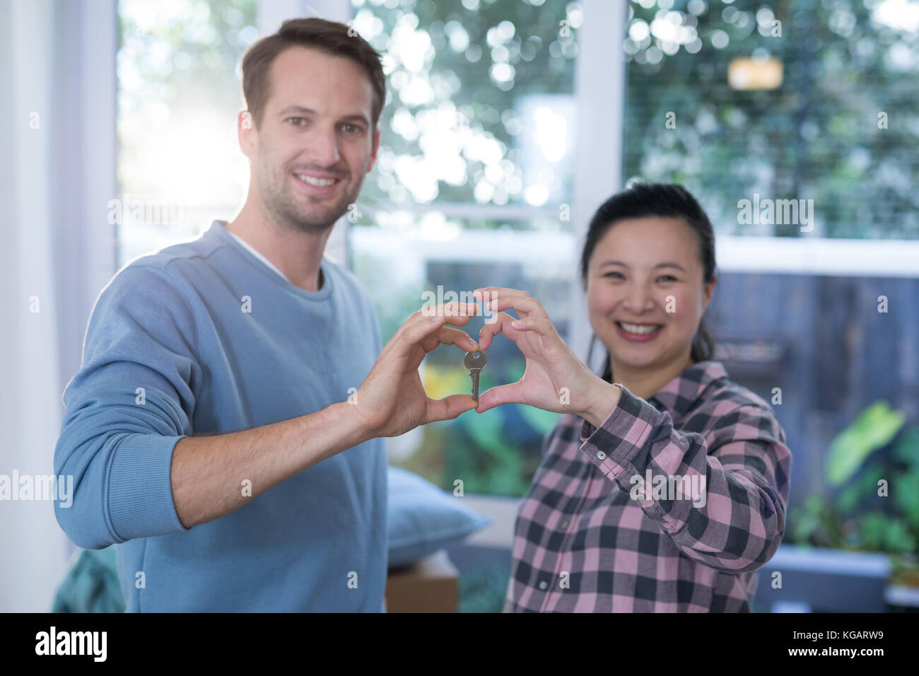 Portrait of smiling couple making heart shape with hands Stock Photo ...