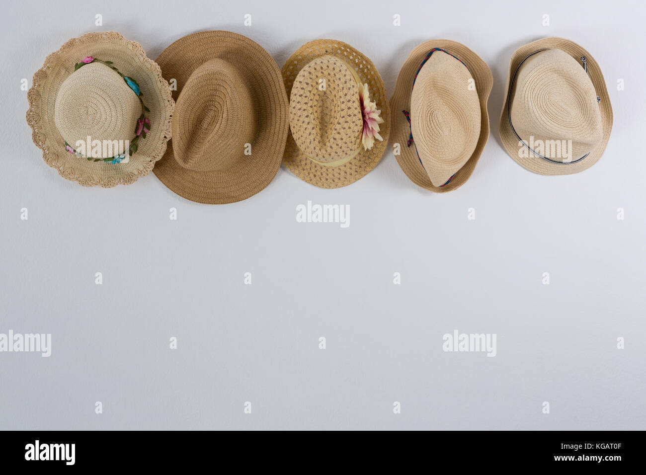 Various straw hats hanging on hook against wall Stock Photo Alamy