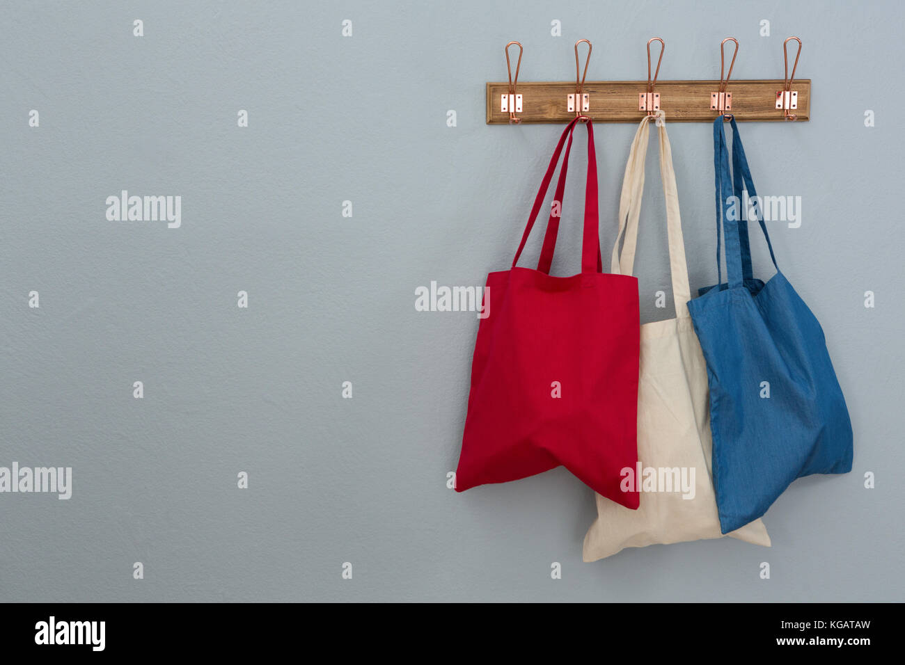 Various handbags hanging on hook against wall Stock Photo Alamy