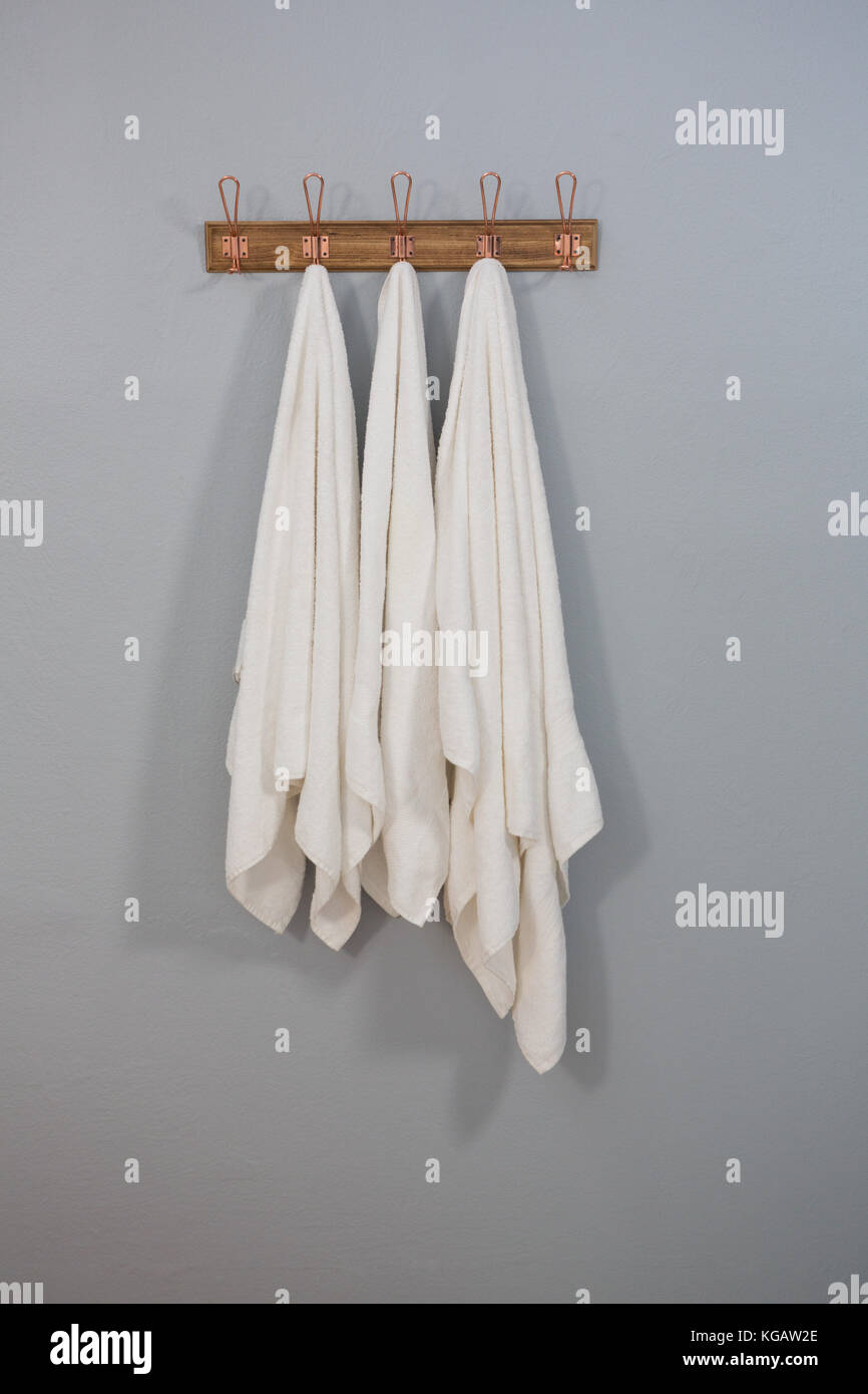 White towels hanging on hook against wall Stock Photo Alamy