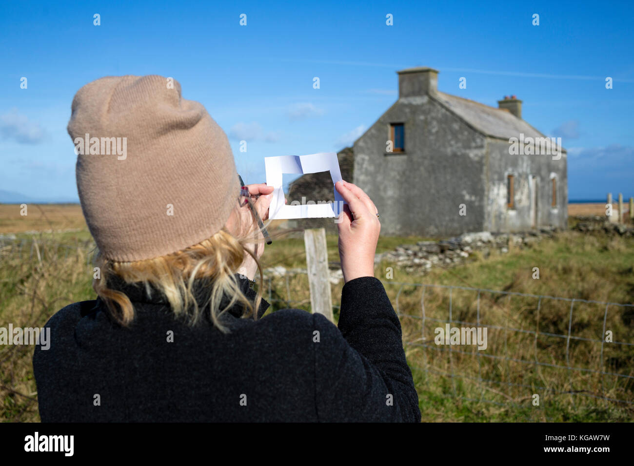 Woman artist framing scene with paper viewfinder Stock Photo