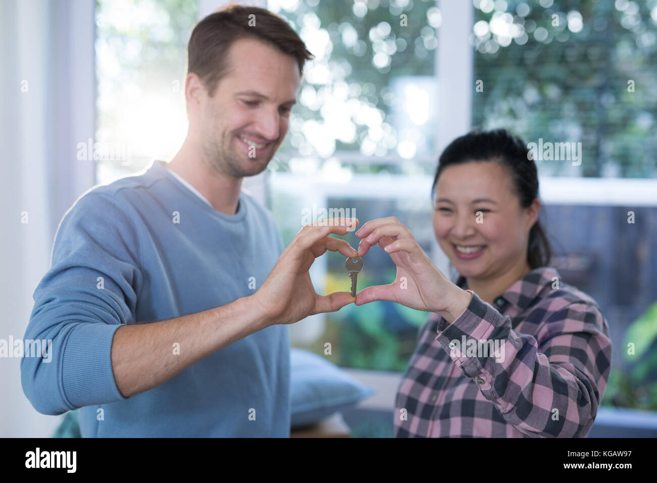 Couple making heart shape with hands at new home Stock Photo - Alamy