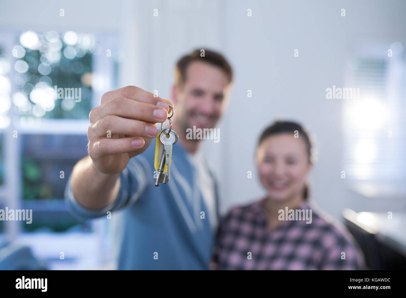 Happy couple showing a key of their new house Stock Photo - Alamy