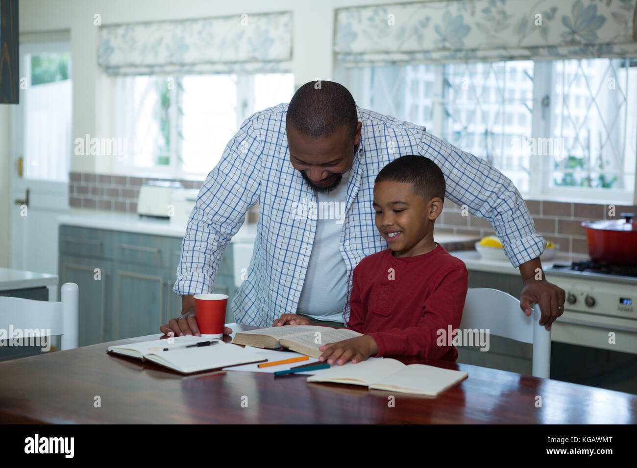 Father helping his son with homework in kitchen at home Stock Photo - Alamy